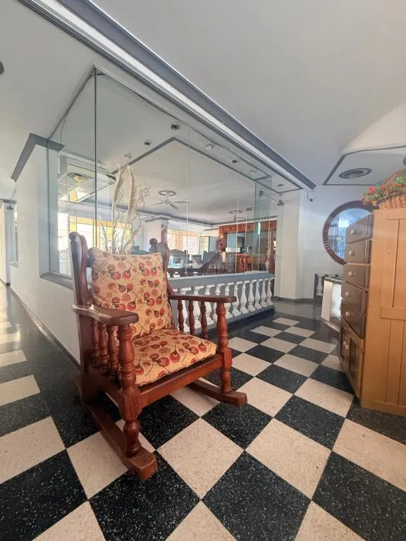 Lobby del Ambrosio Residencial con silla mecedora y piso ajedrezado