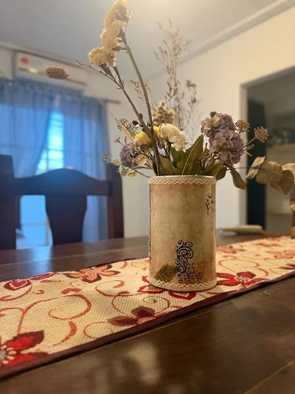Jarrón de flores secas decorativo sobre mesa del comedor